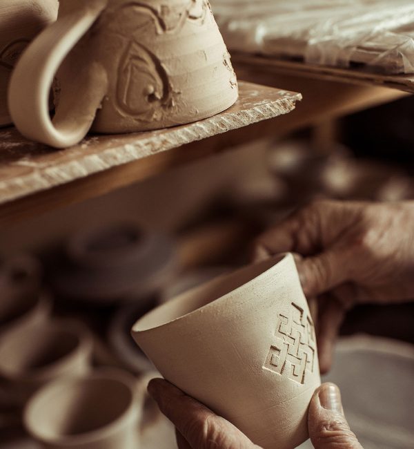 close-up-of-male-hand-of-potter-examining-clay-cup-resize.jpg